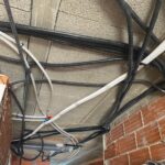 Instalación de tubería corrugada y cableado denso en techo y pared de ladrillo en obra en Valencia